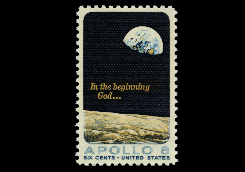 US‑Briefmarke von 1969 mit dem berühmten ‘Earthrise’-Foto der Apollo‑8‑Mission und dem Schriftzug ‚In the beginning God…‘ – ein Symbol für den Blick auf unsere fragile Erde aus dem All.